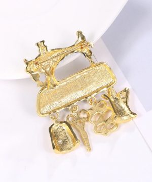 Prepracovaná brošňa v tvare stroja na šitie s doplnkami