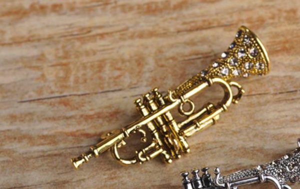 Prepracovaná vintage brošňa na oblečenie v tvare saxofónu