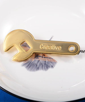 Štýlová brošňa v zlatom spracovaní - kľúč CREATIVE